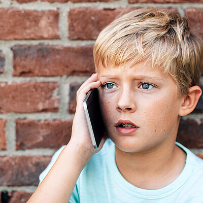 Ein Junge am Handy telefoniert 