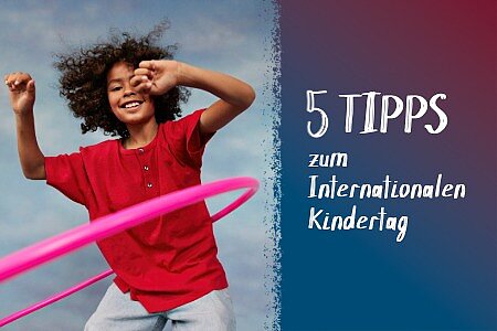 Eine Junge in rotem T-Shirt lässt einen Hula Hoop Ring kreisen.