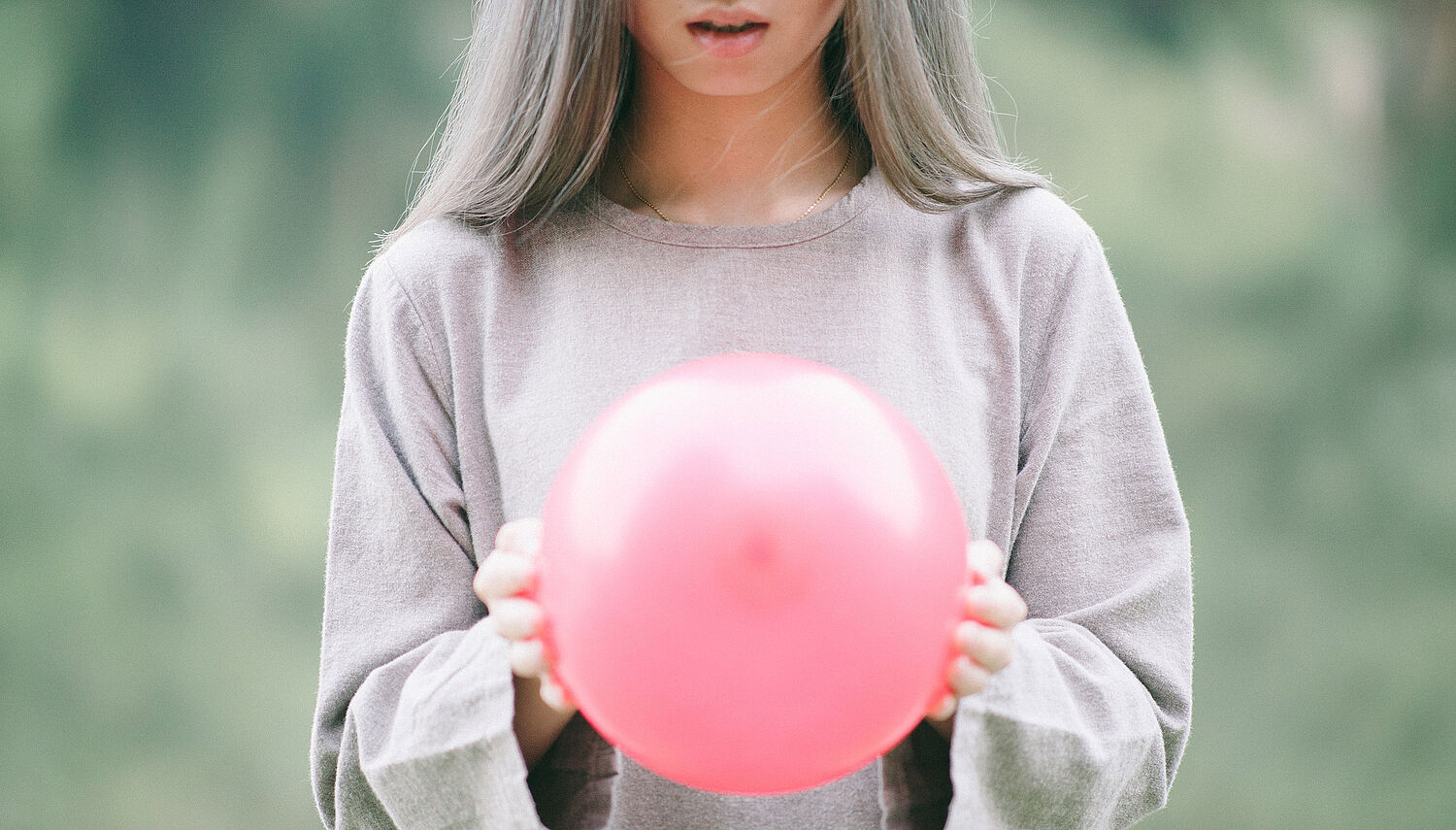 Junge Frau mit einem pinken Luftballon